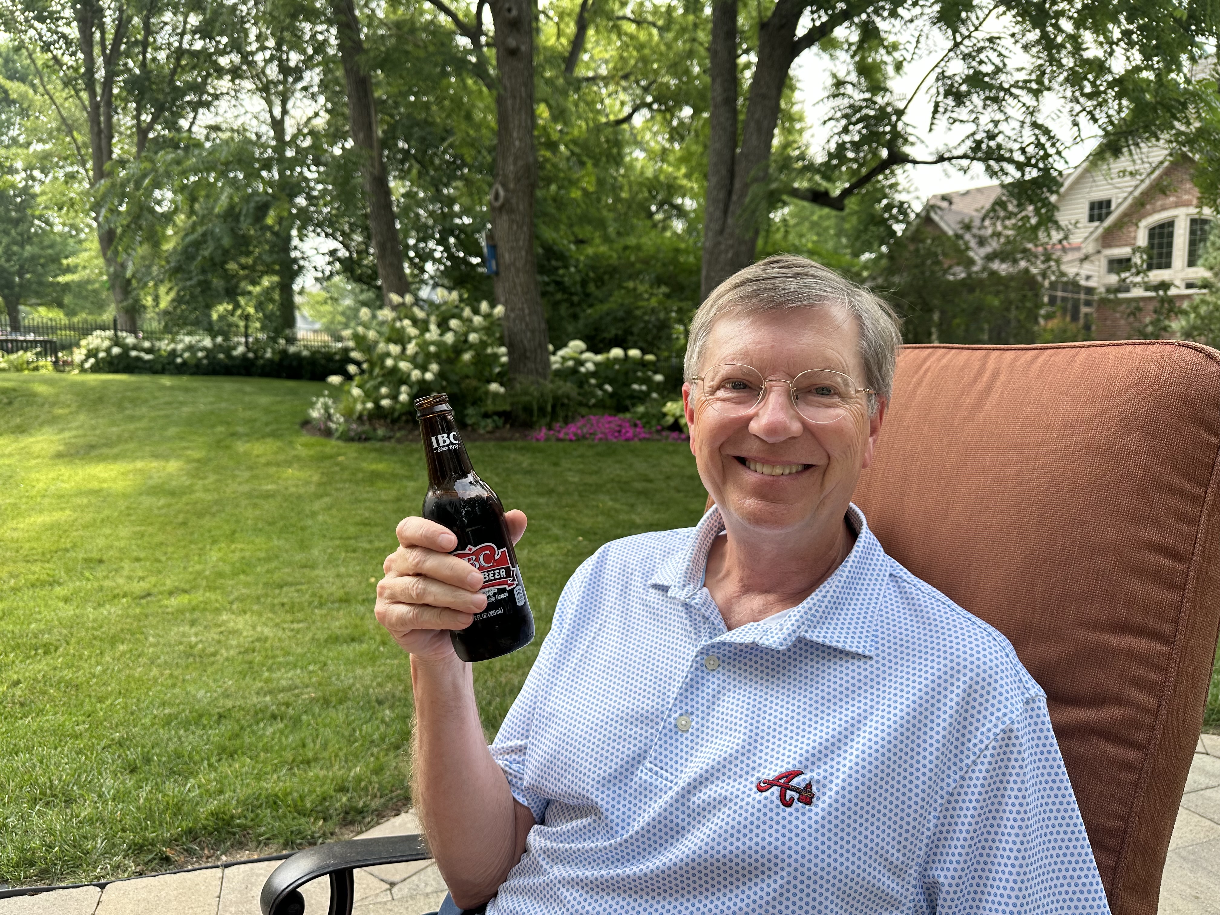 John H. Wilson outdoors, relaxed and holding a root beer
